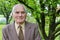 Handsome 80 plus year old senior man posing for a portrait in his garden