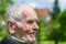 Handsome 80 plus year old senior man posing for a portrait in his garden