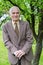 Handsome 80 plus year old senior man posing for a portrait in his garden