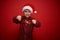 Handsome adorable preteen boy, pretty child in Santa Claus hat and checkered shirt enjoys the Christmas party, plays with Bengal