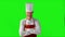 Handsome adult chef turns, he crosses his arms and nods his head on a green background