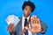 Handsome african american business man with afro hair holding canadian dollars with open hand doing stop sign with serious and