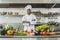 handsome african american chef standing at restaurant kitchen with crossed arms and looking