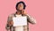 Handsome african american man with afro hair holding blank empty banner serious face thinking about question with hand on chin,