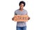 Handsome african american man with afro hair holding strike banner cardboard looking positive and happy standing and smiling with