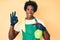 Handsome african american man with afro hair wearing apron holding cleaning spray doing ok sign with fingers, smiling friendly