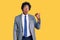 Handsome african american man with afro hair wearing business jacket surprised pointing with hand finger to the side, open mouth