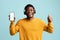 Handsome african american man with headset showing cellphone, mockup