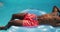 Handsome african american man lying on inflatable sunbathing in swimming pool