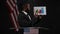 Handsome African American man pointing at graph talking with USA flag at black background. Portrait of confident serious