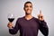 Handsome african american sommelier man tasting glass of red wine over white background surprised with an idea or question