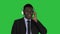 Handsome Afro American businessman in headphones is listening to music on a Green Screen, Chroma Key.