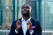 Handsome Afro businessman in a stylish black suit looking into the sky and praying on street background office