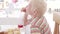 Handsome albino boy drinks cherry juice at a hotel restaurant.