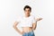 Handsome androgynous man in crop top looking confused, shrugging clueless, standing over white background