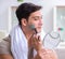Handsome applying clay mask on face