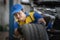 Handsome asian auto mechanic in uniform is examining a tire while working