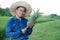 Handsome Asian man farmer wears hat, blue shirt, holds pineapple fruit.