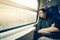 Handsome asian man looking through train window, warm light tone, with copy space