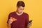 Handsome astonish guy holding slice of tasty pizza and phone, checking social network while having snack, sees braking news,