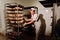 Handsome baker in uniform holding tray full of freshly baked bread at the manufacturing