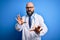 Handsome bald doctor man with beard wearing glasses and stethoscope over blue background disgusted expression, displeased and