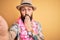 Handsome bald man with beard and tattoo on vacation wearing summer hat and hawaiian lei cover mouth with hand shocked with shame