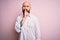 Handsome bald man with beard wearing elegant shirt over isolated pink background asking to be quiet with finger on lips