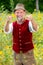 Handsome bavarian man in his 50s standing in garden with thumbs up