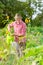 Handsome bavarian man standing in the garden and watering the flowers