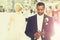 Handsome bearded african American groom touches wedding ring on finger