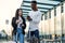 Handsome bearded african american guy and asian pretty girl gathering on business trip with suitcases waiting at stop.