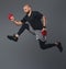 Handsome bearded athlete in sportswear jumping in a studio.