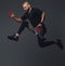 Handsome bearded athlete in sportswear jumping in a studio.