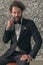 Handsome bearded groom holding arms in fashion pose and looking to side