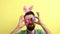 Handsome bearded man in bunny ears funny dancing with eggs happy easter