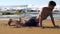 Handsome bearded man stands on sandy beach in yoga position