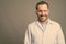 Handsome bearded Persian man doctor wearing protective glasses against gray background