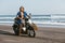 handsome biker sitting on scooter at beach