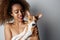 Handsome black american african girl embracing puppy on white background. Studio portrait of white appealing female