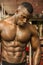 Handsome black male bodybuilder resting after workout in gym
