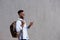 Handsome black man with bag and cellphone walking by wall