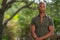 Handsome black model posing outdoors in nature scene blurry trees with background bokeh