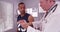 Handsome black sports athlete having injury examined by elderly white doctor