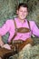 Handsome blond bavarian man sitting in hay