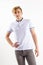 Handsome blond boy teenager in white shirt stands