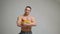 Handsome bodybuilder holding fresh fruits and posing on white background. Organic food and health concept