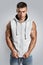 Handsome bodybuilder wearing gray sleeveless hoodie