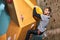 Handsome boulderer hanging on large hold at colorful climbing wall