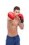 A handsome boxer, with a muscular naked torso, s, strikes in front of him.